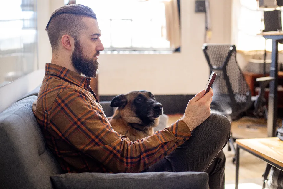 A man at home on his sofa, messaging on his phone