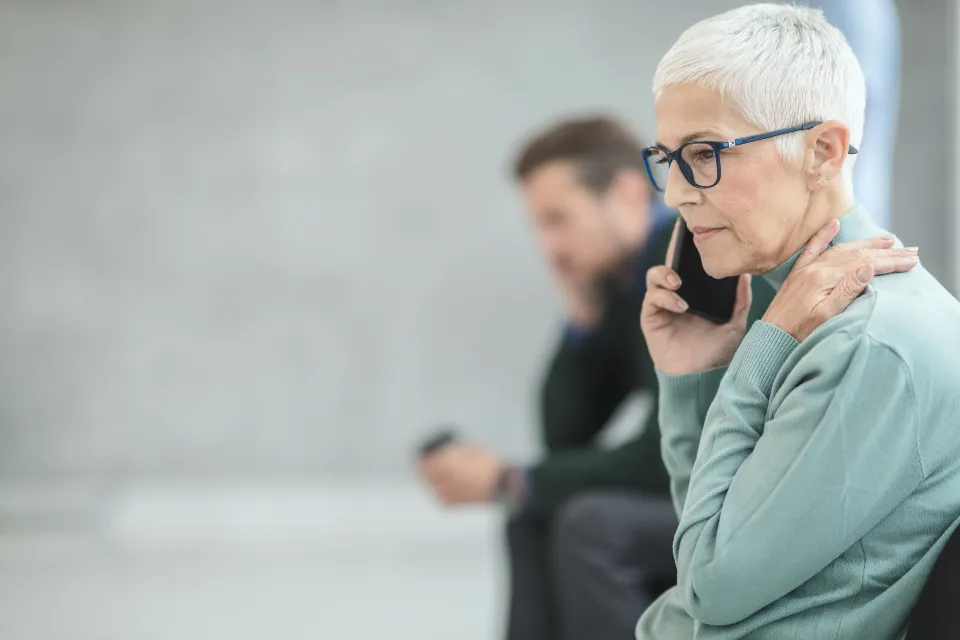 A woman waiting on hold on the phone